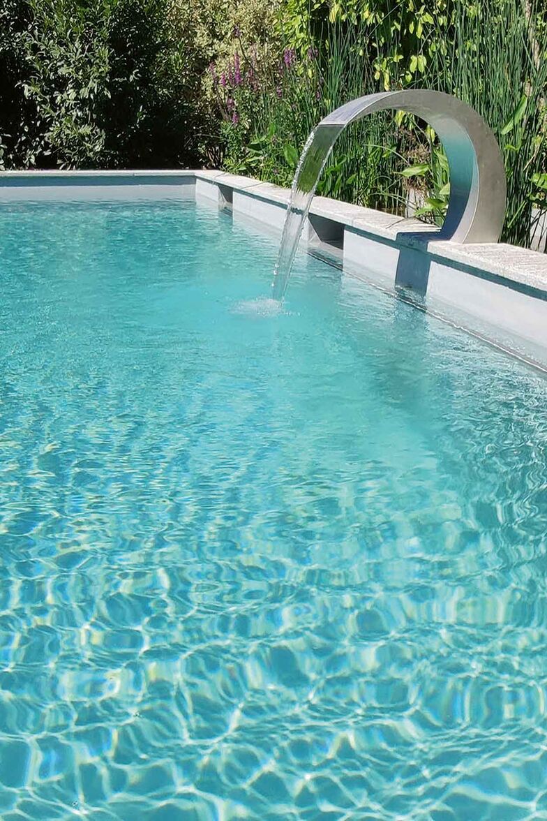 Naturpool mit Granit: Für den Familiengarten bietet der als Betonbecken konstruierte Naturpool einen grosszügigen Schwimmbereich. Die Wasseraufbereitung funktioniert biologisch; der Kiesfilter wurde mit Wassergräsern bepflanzt und begleitet die Naturpoolanlage. Zusätzlich setzen insektenfreundliche, langblühende Sumpfpflanzen Farbtupfer. Lehnert AG. www.gartenzentrum.ch