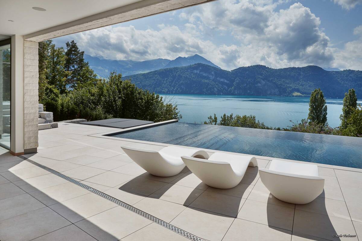 Der Betonpool mit dunkelgrauer Folienauskleidung «Alkorplan Touch Elegance» lässt das Poolwasser farblich wie einen kristallklaren See anmuten. Der massgefertigte Pool ist unter anderem mit Massagedüsen und einer Gegenstromanlage ausgestattet. Die Wasserreinigung erfolgt automatisch. Vita Bad AG.