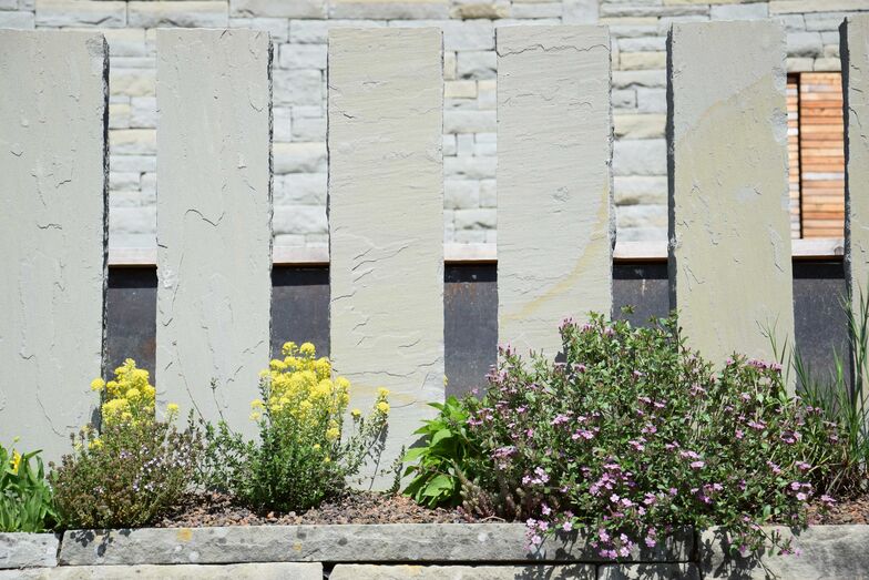Der Sichtschutz aus Sandstein ist ein Element des Gartenbaus aus einer Hand. Abderhalden Gartenbau AG, www.abderhalden.ch
