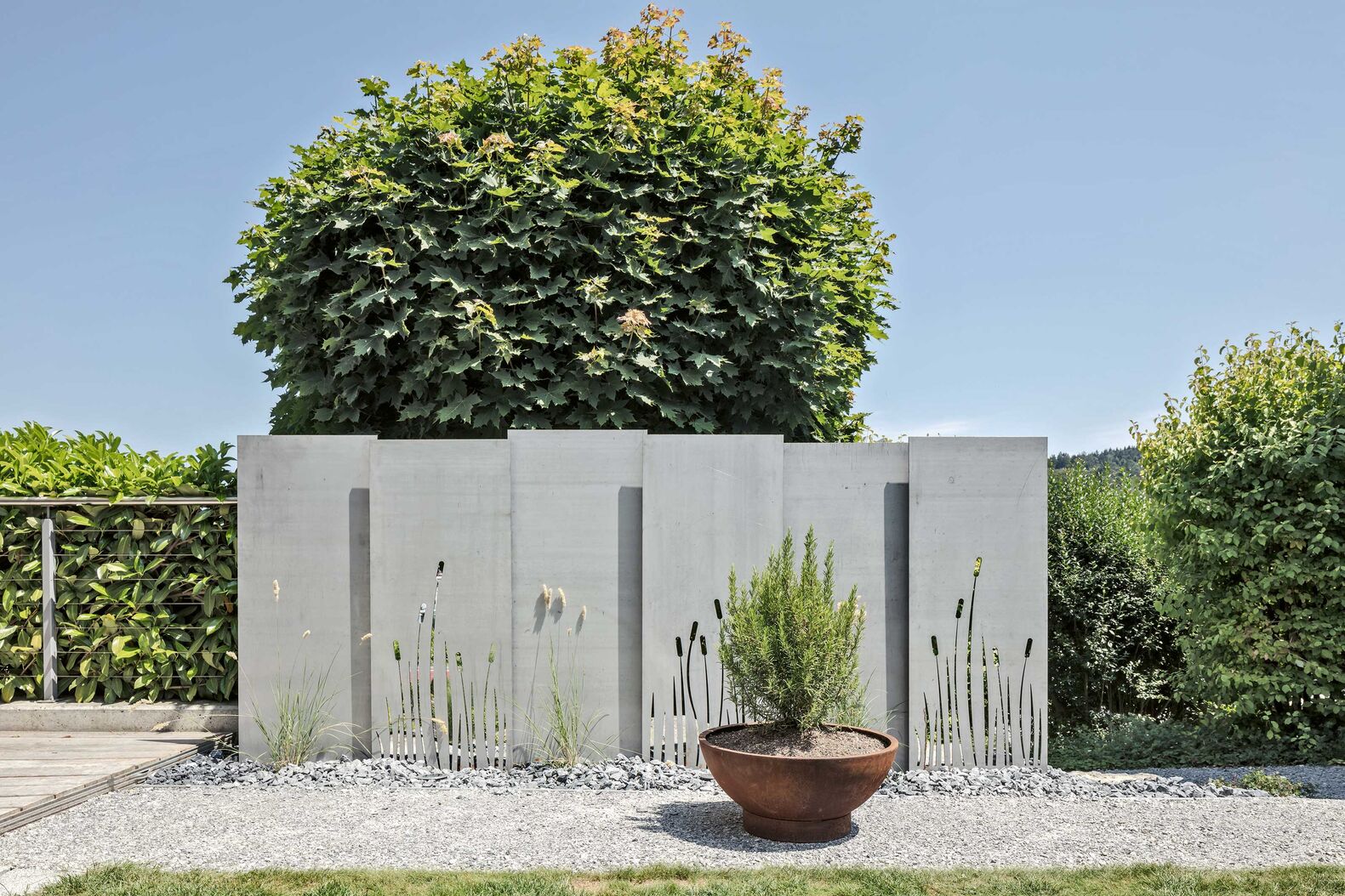 Sichtschutzelemente aus Stahl, Cortenstahl oder Edelstahl halten auch Wind und Lärm ab. Eine stimmige Beleuchtung kann als weiteres Element hinzugefügt werden. PM Outdoor Design, www.pmoutdoordesign.ch