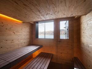 Die extralange Liegefläche direkt vor dem Fenster mit Blick auf den See war ein Wunsch der Bauherrschaft. Ebenso die Tür, die direkten Zugang zum Aussenplatz und zum Sprung ins kühle Nass bietet. Küng Wellness AG.