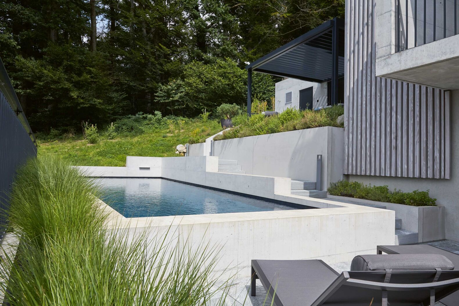 Der exklusive Betonpool misst 11,5 x 4 Meter und ist mit Düsen, Beleuchtung und einem Rollladen ausgestattet. Vita Bad AG, www.vitabad.ch