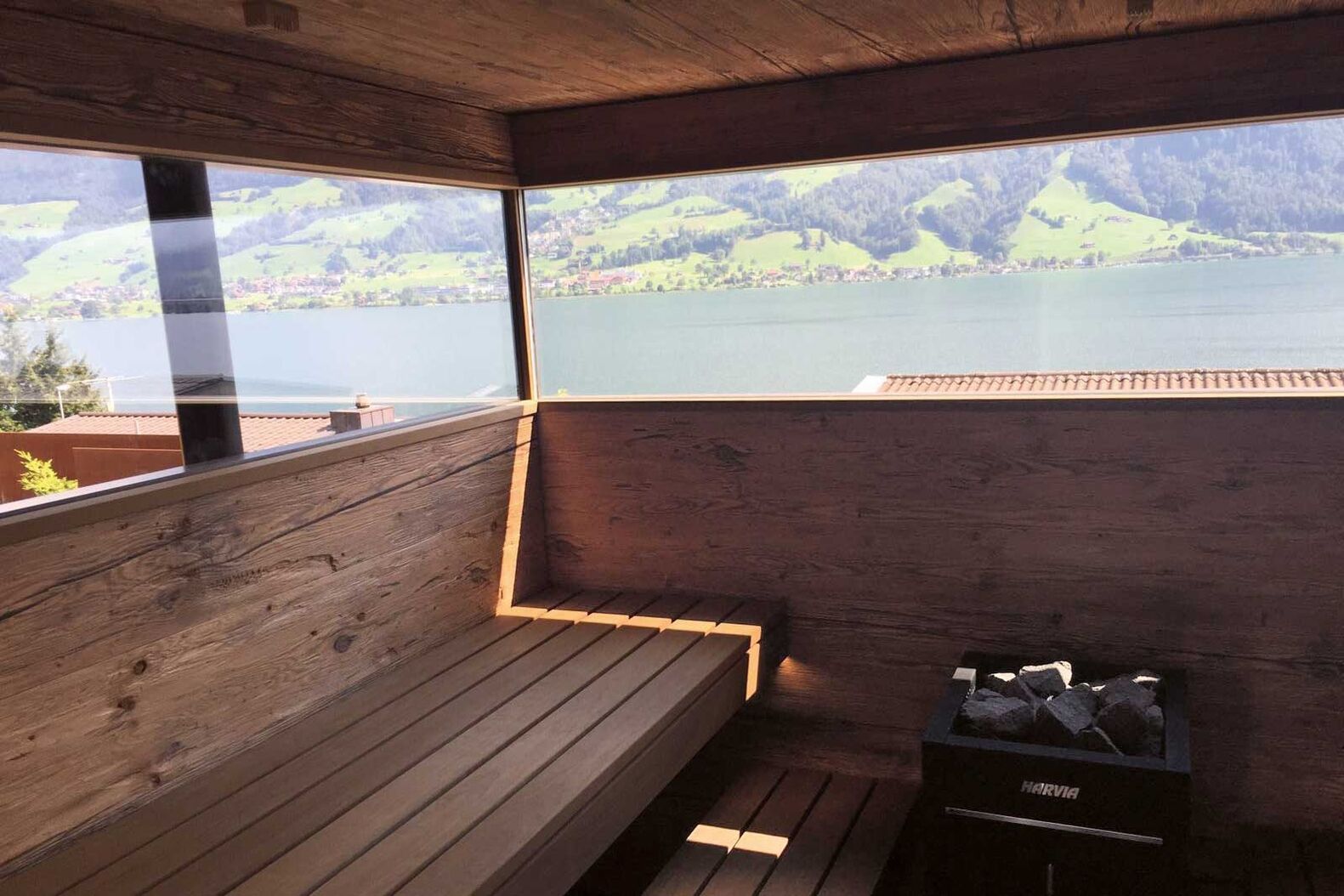 Sauna mit Seeblick. Die aus Altholz gefertigte Anlage kombiniert finnische und Bio-Sauna. Ging Saunabau AG, www.saunabau.ch
