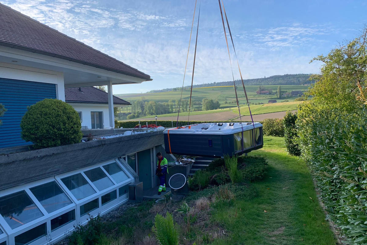 Der Whirlpool hängt am Kran und wird zunächst vor dem Haus abgesetzt.