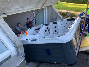 Die Profis transportieren den Pool bis zu seinem Standort im Garten.