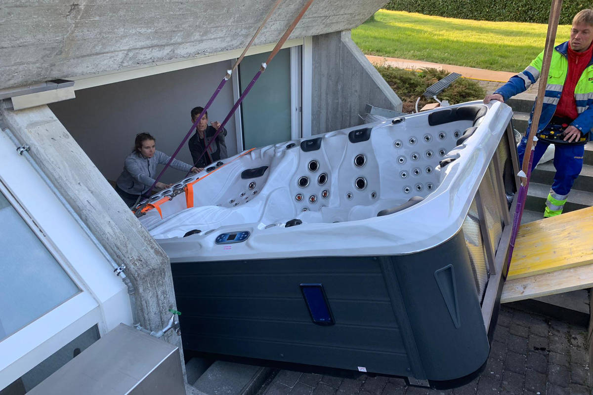 Die Profis transportieren den Pool bis zu seinem Standort im Garten.