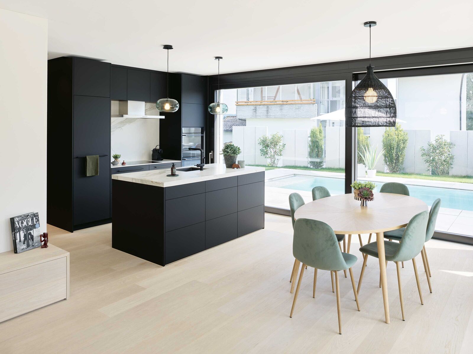 Die dunkle Küche ist ein schöner Kontrast zum hellen Eichenparkett.