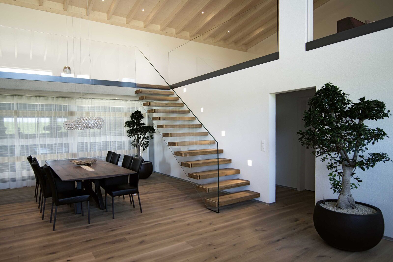 Eine stilvolle Kombination von Massivholz mit Glas vermittelt bei der freitragenden Treppe zeitlose Eleganz und Wertigkeit.
