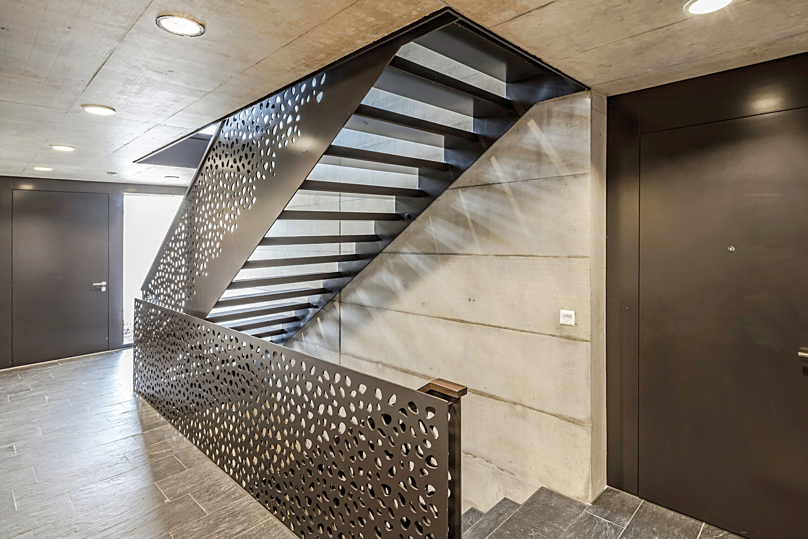 Ein Geländer aus gelastertem Stahlblech gibt der offenen Metalltreppe die nötige Sicherheit. Ferdinand Hassler AG.