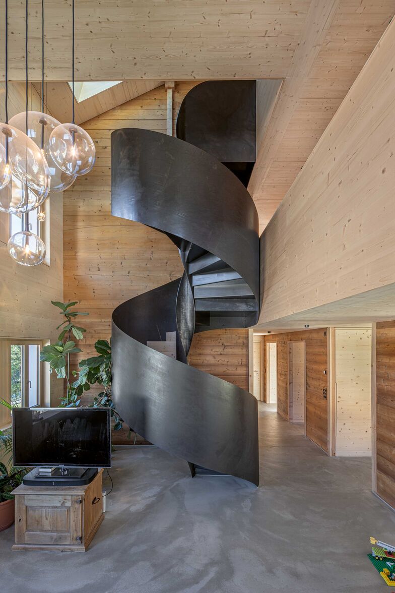 Platzsparend und ausdrucksstark: Die Wendeltreppe aus roh geöltem Stahl verbindet drei Stockwerke in einem Umbau in Blockbauweise. Architektur: Vomsattel Wagner Architekten, Visp, Foto: Andenmatten Soltermann. Gyger Metallbau AG, www.gygertreppen.ch