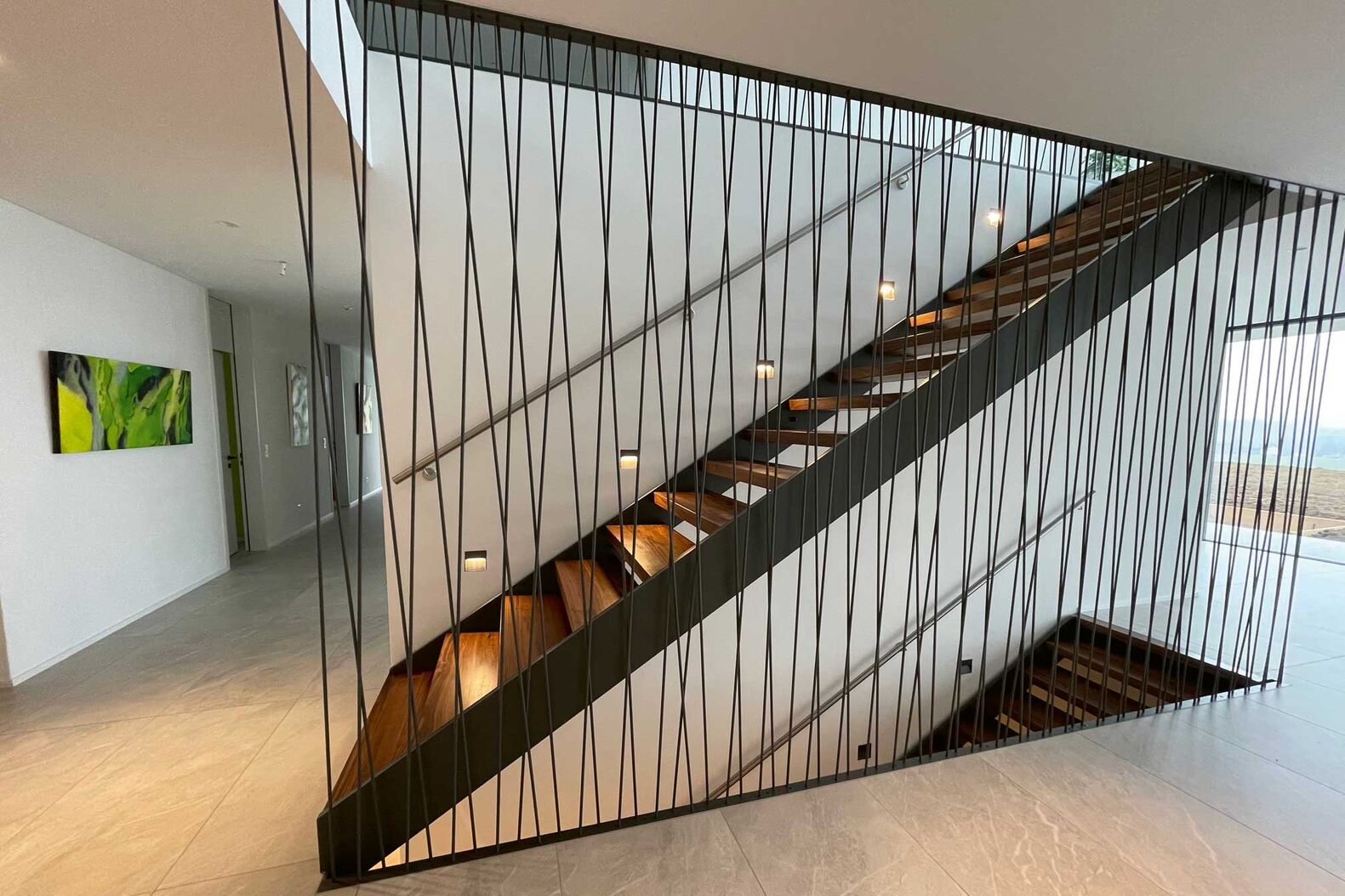 «Lust fürs Auge, keine Last für die Beine»: Das ist die Treppenphilosophie bei Langegg Treppenbau. Dieses Beispiel besticht durch die Geländerwand mit schräg versetzten Stahlsprossen. Langegg Treppenbau, www.langegg.ch