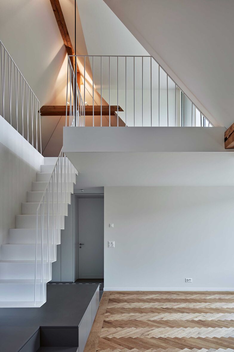 Filigrane, ans Sideboard angedockte Stahlfaltwerktreppe mit Staketengeländer aus Rundstahl. Entwurf: Ernst Gerber Architekten + Planer AG. Foto: Damian Poffet. Gyger Metallbau AG, www.gygertreppen.ch