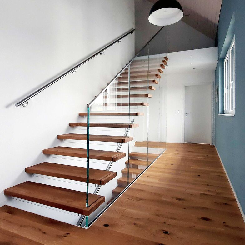 Glaswände halten wandseitig mit Bolzen montierte Eichenstufen. Transparente Kinderschutzleisten und CNS-Handläufe mit LED-Beleuchtung machen die Anlage zu einem Blickfang. Columbus Treppen AG, www.columbus.ch