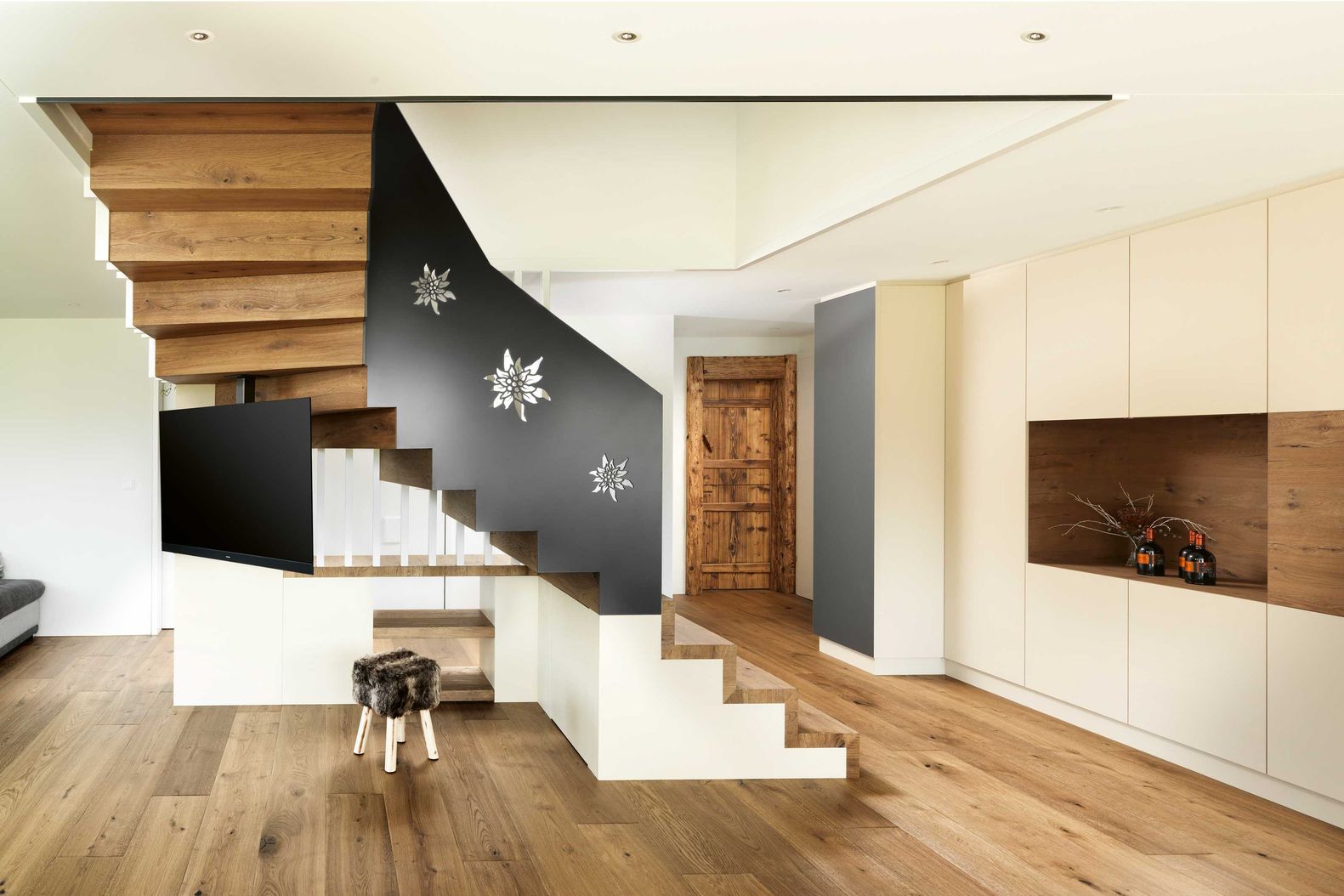 Bei dieser viertelgewundenen Treppe in Massivholz wurden am aussenseitigen Metallgeländer Edelweissmotive ausgestanzt. Ambauen Treppen AG.