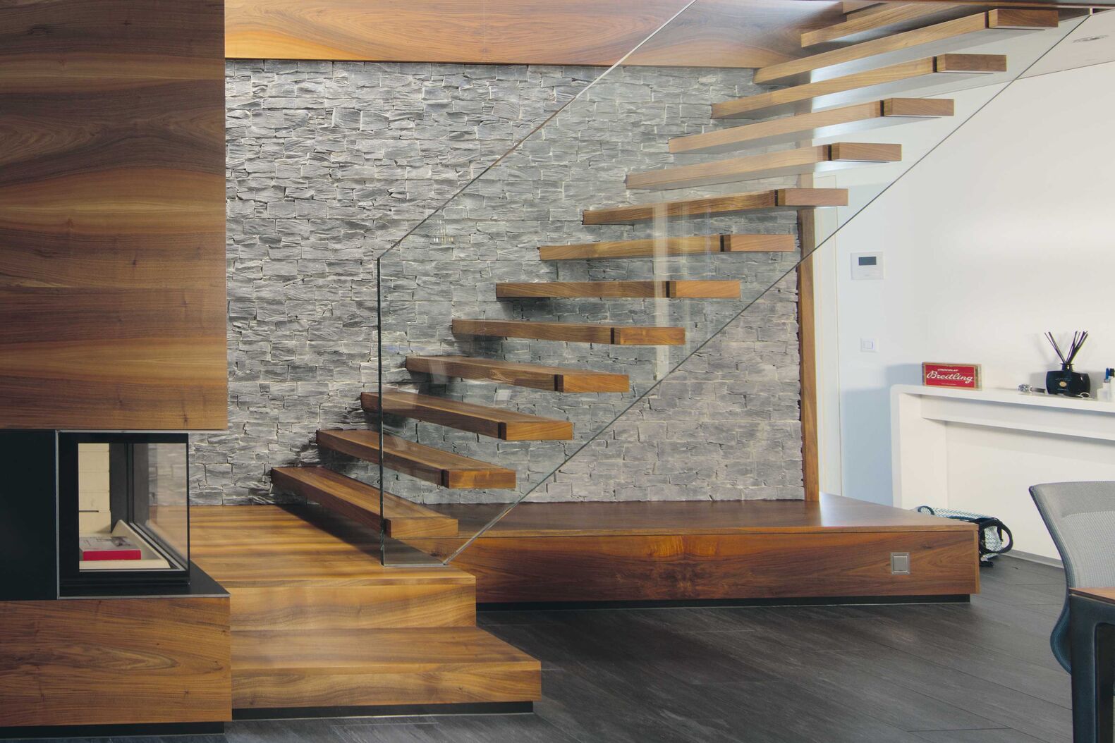 Stufen in Amerikanischem Nussbaum lackiert wurden direkt zwischen die Wand und die Glasbrüstung montiert. Keller Treppenbau AG, www.keller-treppen.ch