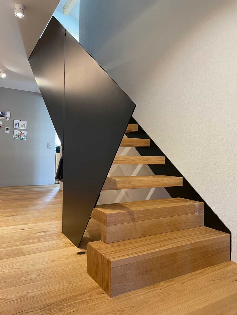 Markante Konstruktion mit Wangen und Geländer in Stahl lackiert, Stufen 80 mm Eiche Natur geölt. Langegg Treppenbau, www.langegg.ch