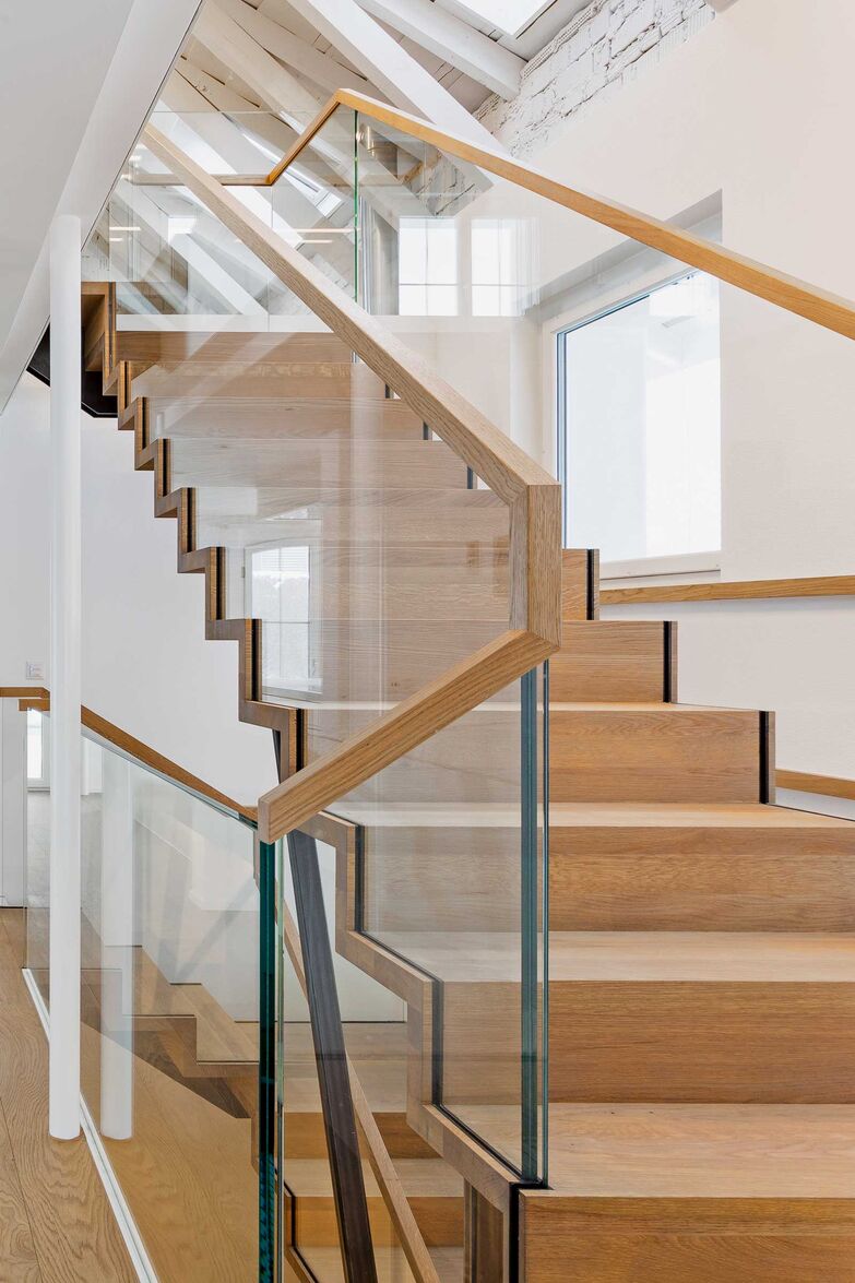 Diese Faltwerktreppe aus massiver Eiche von Gyger Metallbau wird durch den doppelten Mittelholm und die Stützen getragen und bildet mit den Ganzglasgeländern einen Verbund. So wurde es möglich, eine sehr feingliedrige Treppe zu bauen, die auch hohe Kräfte abträgt. Gyger Metallbau AG, www.gygertreppen.ch