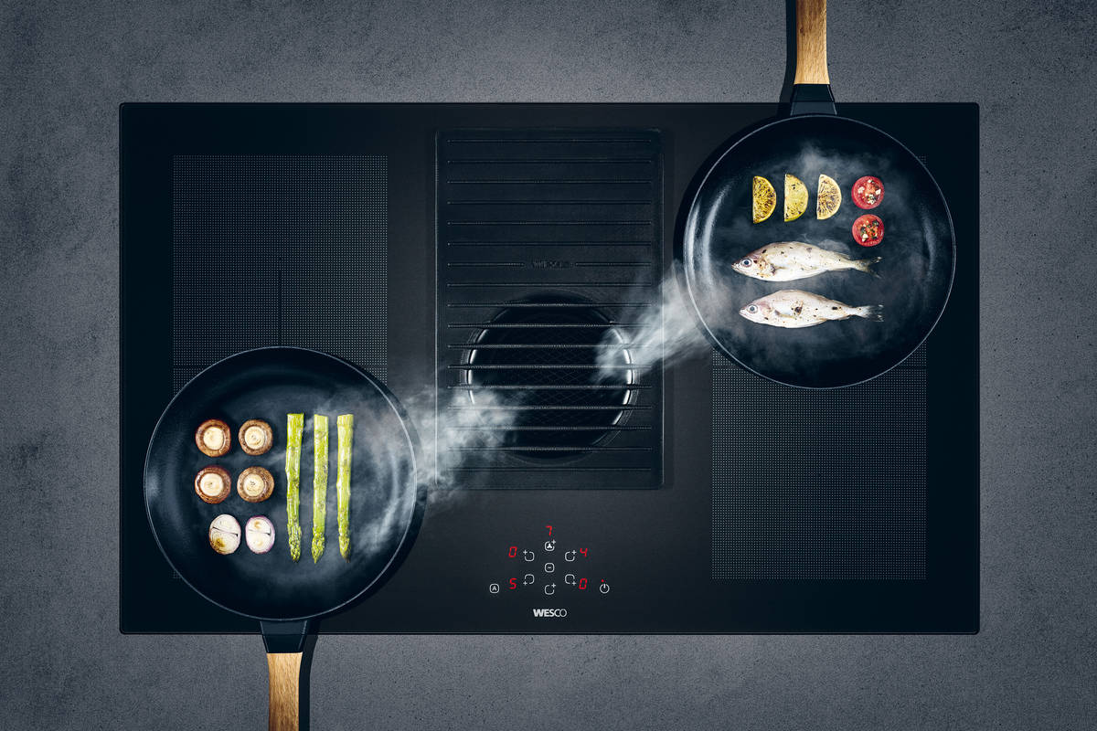 Lüfter «Pura» ist mit den Heizstufen des Kochfelds gekoppelt. Den Filter einigt man im Geschirrspüler. Auf dem hitzebeständigen Gusseisengitter kann man auch Töpfe abstellen. Wesco.