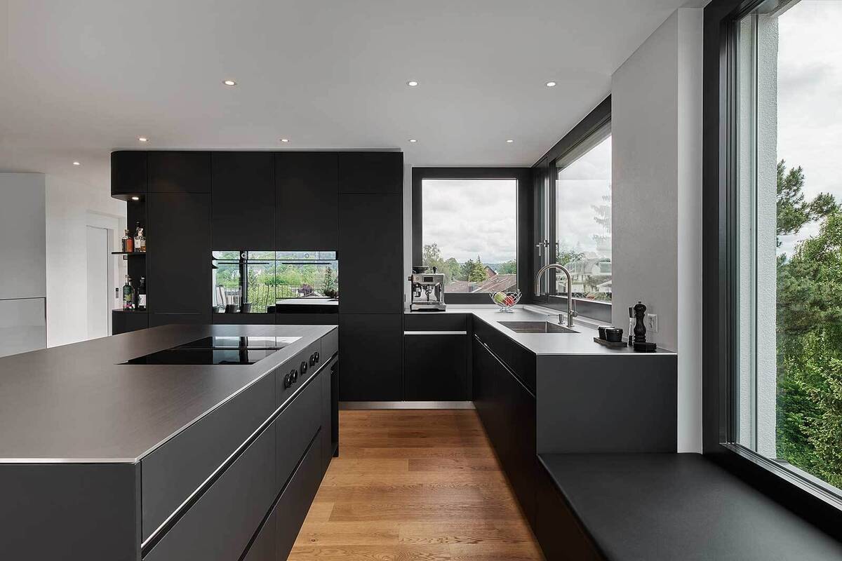 Ein Kontrast kann auch durch die Kombination aus matten «Damastfronten» in Schwarz und der Abdeckung der Kücheninsel im «Ice-Design» erzeugt werden. Dieses Zusammenspiel aus metallischem Glanz und mattem Schwarz bringt ein zeitloses Design in die Küche. Brunner Küchen AG.