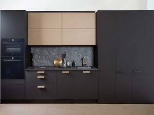 Die mattschwarze Küche mit goldenen Armaturen und Griffen vermittelt Eleganz. Durch die Rückwand und die hellen Oberschränke entsteht am Arbeitsort ein natürlicher Fokuspunkt. Bei der Planung sollte stets berücksichtigt werden, dass wie bei dieser Küche, Backofen und Steamer sich durch das Schwarz optisch in der Küche integrieren und nicht sofort ins Auge springen. Sabag AG.