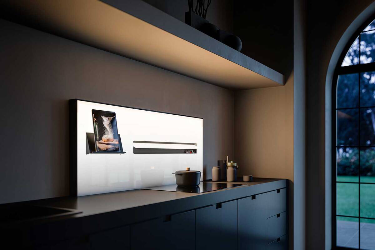 Mit dem vertikal integrierten und hinterleuchteten Dunstabzug verwandelt sich die Rückwand der Küche in eine multifunktionale Oberfläche. Das Magnetsystem ermöglicht zudem das flexible Anbringen von Zubehör auf der ganzen Fläche. Fors.