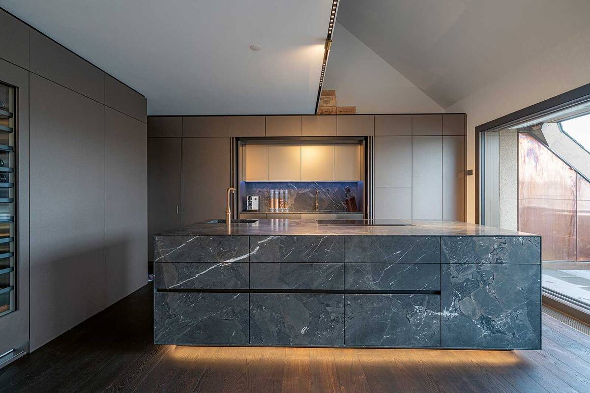 Der Naturstein in der Ausführung «Leather Look», erinnert durch die feine Struktur beim Berühren an Leder. Die feine Textur des brasilianischen Hartgesteins stellt das Abbild der Erde dar. Kontinente, Flüsse, Gebirge und Seen verleihen der Küche Dimension und Leben. Hans Eisenring.