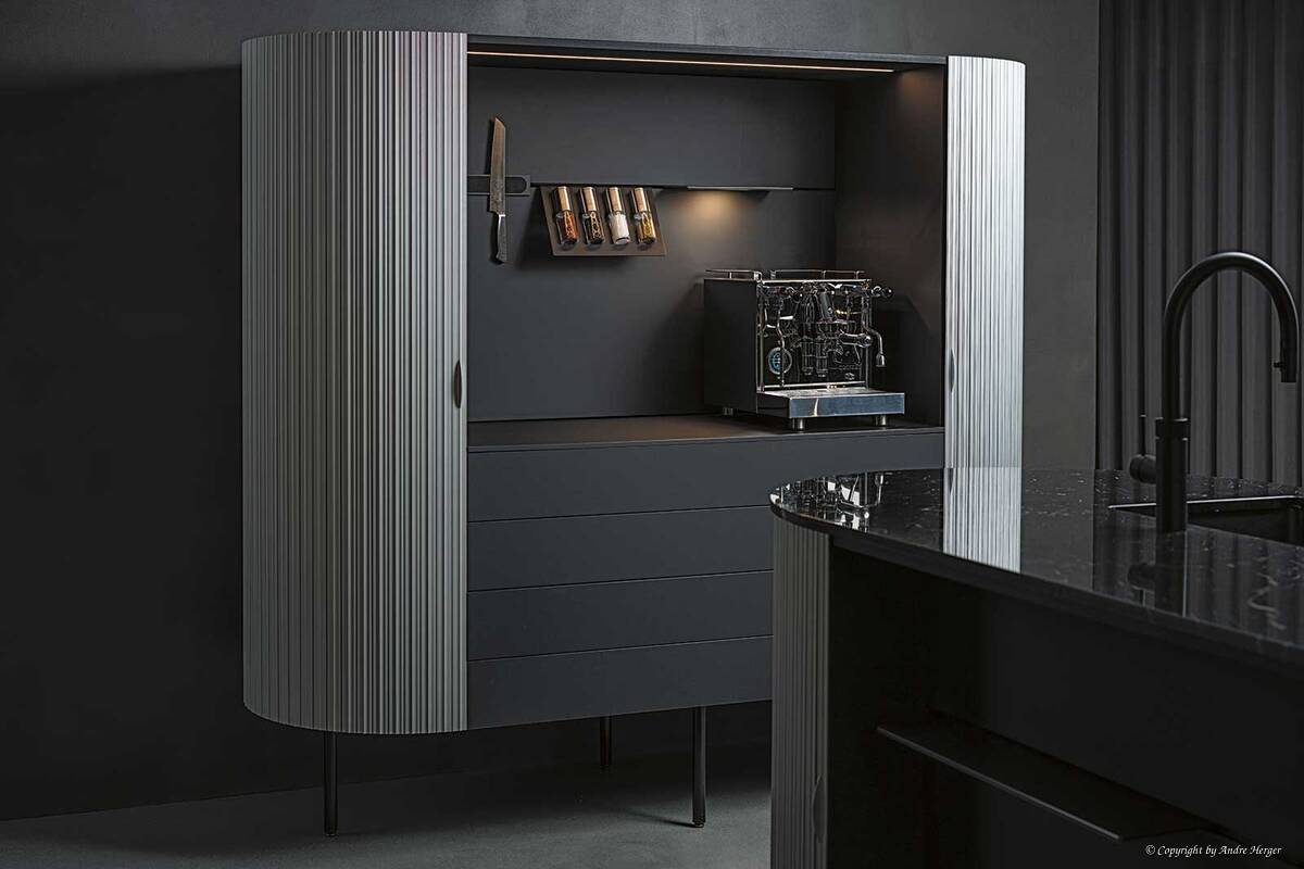 Lady in Black: Zeitlos und puristisch im Stil, hochwertig und edel bei der Materialauswahl. Auffallend dabei: Die Rollfront aus Aluminium umschliesst die dunkle, grifflose Küche nahtlos. Orea Küchen.