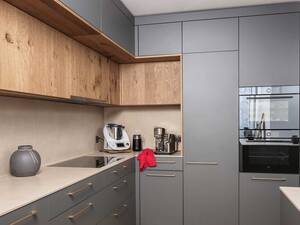 «Trendino» punktet mit viel Stauraum und hoher Alltagstauglichkeit. Graphitfarbene Flächen, die zurückversetzten Schrankfronten in Eiche und die goldenen Griffe bilden ein optisch spannendes Ensemble. Veriset.