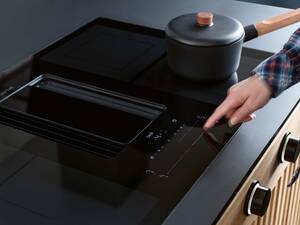 Kraftvoll: «Downline Infinity» heisst die Kombination übergrosses Induktionskochfeld plus leistungsstarke Lüftung: Das Kochfeld wird digital gesteuert, optional auch mit Drehknöpfen in Schwarz oder Edelstahl. Die Koch- und Bratdünste werden nach unten abgesaugt und durch einen Fettabscheider geleitet. Für Abluft, Umluft mit Aktivkohle oder Umluft mit Plasmafilter. Wesco AG.