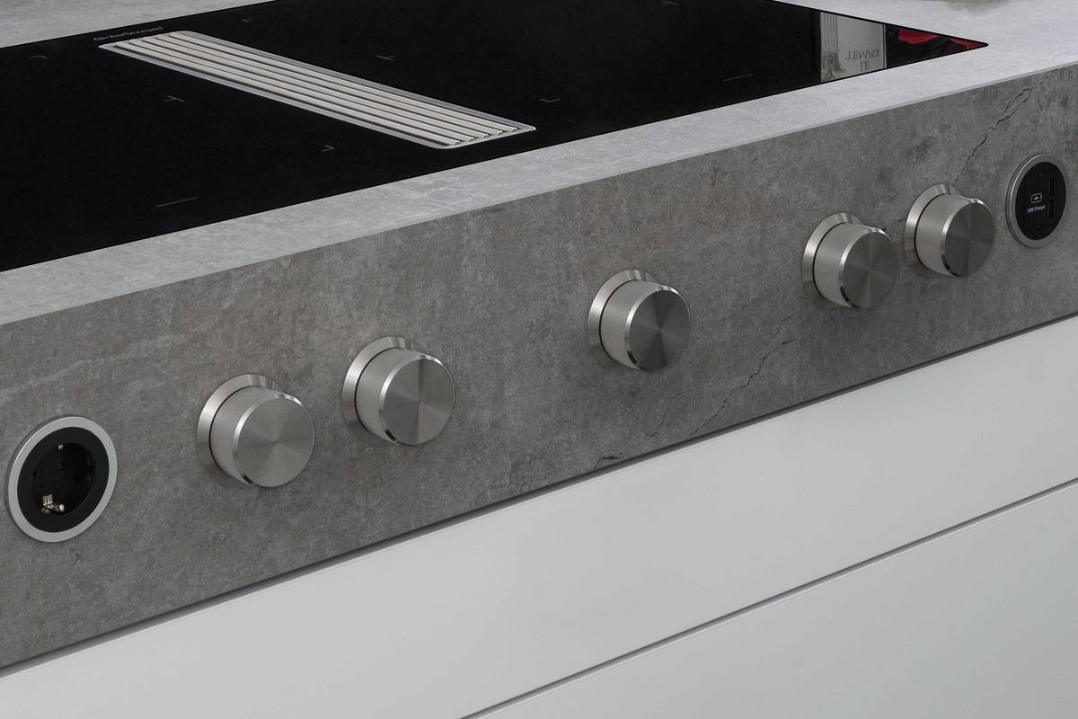 Der Drehknopf ist zurück, kugelgelagert und aus massivem Edelstahl. Je zwei Kochzonen des Induktionsherds können zusammengeschaltet werden. Der Sockellüfter mit flächenbündigem Abdeckgitter ist mittig in die Ceranoberfläche integriert. «Interia Control 2021», ERGE AG.