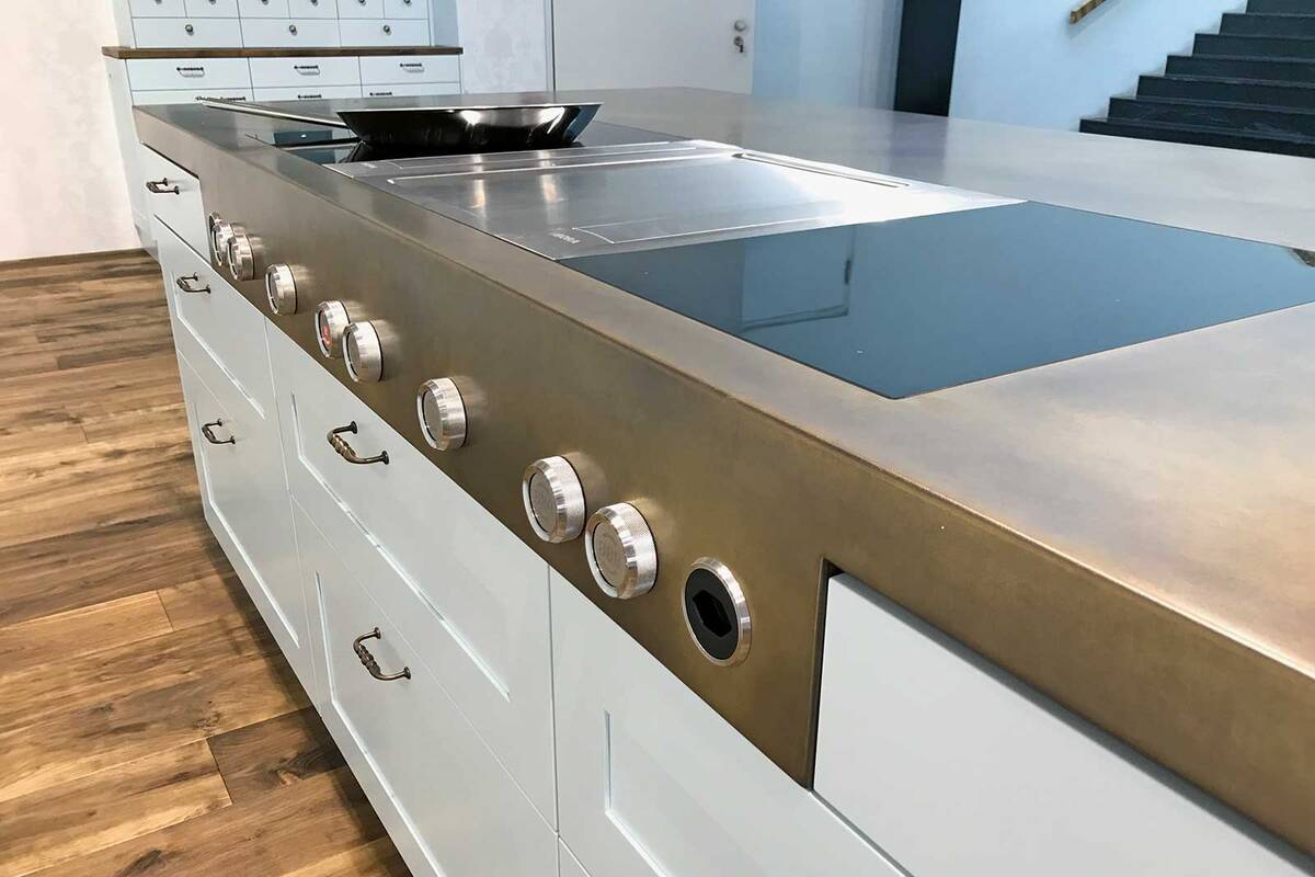 Wenn es um Metall in verschiedenen Formen und Grössen geht, so ­sind der Fantasie und Kreativität (fast) keine Grenzen gesetzt. Diese Arbeitsplatte aus Messing ist mit einem Wirbelfinish patiniert, und eine angeschweisste Blende mit Bedienknebel setzt elegante Akzente. Merial AG.