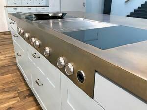 Wenn es um Metall in verschiedenen Formen und Grössen geht, so ­sind der Fantasie und Kreativität (fast) keine Grenzen gesetzt. Diese Arbeitsplatte aus Messing ist mit einem Wirbelfinish patiniert, und eine angeschweisste Blende mit Bedienknebel setzt elegante Akzente. Merial AG.