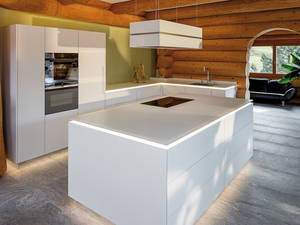 Geradlinig und modern. Die Arbeitsfläche aus Glas wirkt durch LED-Beleuchtung wie schwebend auf der Kücheninsel. Furrer Küchen.