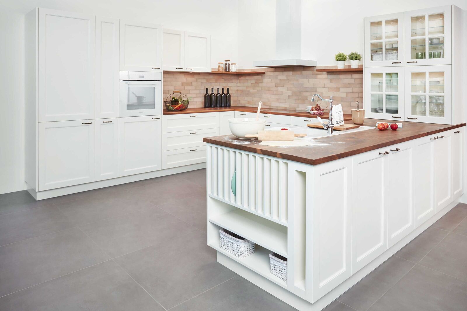 Traditionell und rustikal Diese Stilwelt gibt sich klassisch, mit einer Prise Romantik, sie vermittelt Wärme und Vertrautheit durch Komponenten, die schon bei den Grosseltern im Einsatz waren: In dieser Küche fühlt sich die ganze Familie wohl. Die verglasten Geschirrschränke und die Fronten im Landhausstil unterstreichen ihren Charakter. Griffe und Arma­turen in nostalgisch geschwunge­ner Form sind dabei das Tüpfelchen auf dem «i».