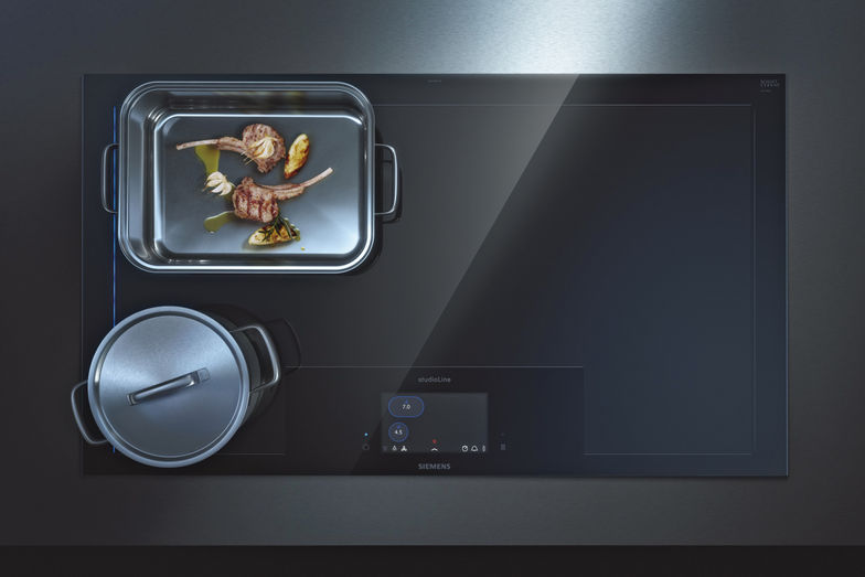 Aktionsraum Küche: In modernen Wohnräumen ist ein minimalistischer Look Trend. Darauf geht Siemens mit dem «activeLight» Kochfeld ein. Auf diesem sind weder vorgezeichnete Kochzonen noch Bedienfeld zu sehen. Dadurch, dass sie flächenbündig in die Arbeitsplatte, die beispielsweise aus schwarzem Granit, Kunststein oder Keramik besteht, eingelassen werden kann, entsteht eine durchgängige Ästhetik ohne Knöpfe und Bedienfelder. Siemens ersetzt sie durch blaues Licht und intelligente Technik. Die automatische Zonenauswahl erkennt sofort, wo Pfanne oder Topf stehen und markiert sie durch blaue Lichtstreifen. Die «varioInduktion»-Technologie stellt sicher, dass alles gleichmässig beheizt wird. Darüberhinaus bringt die «cookConnect»-Funktion das «activeLight»-Kochfeld und den passenden Dunstabzug in Einklang, sodass die Leistung an die aufsteigende Dunstmenge angepasst wird.