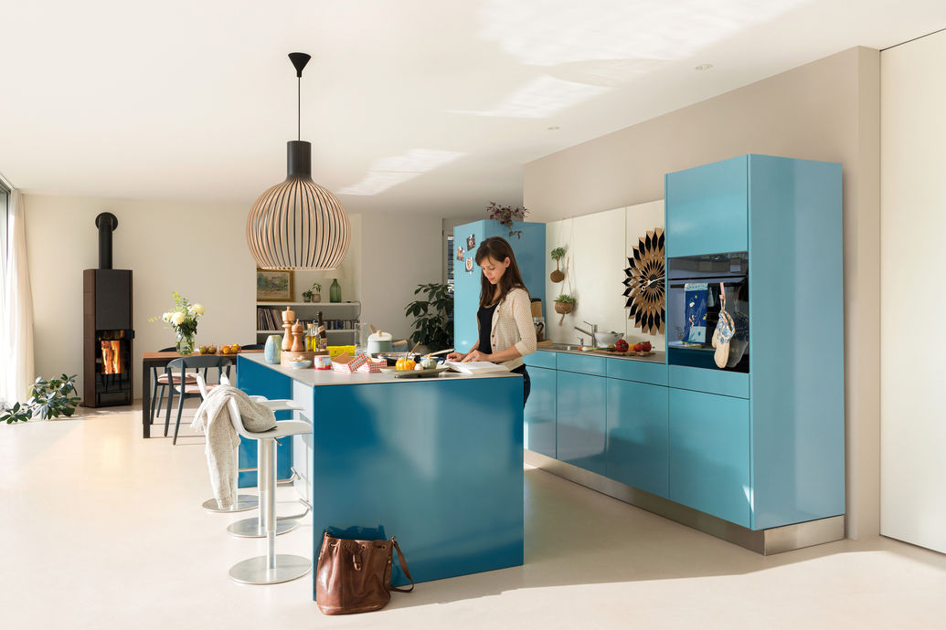 Diese Küche hat eine wasserblaue Pulverbeschichtung. Dank des Tip-On-Systems werden die Oberflächen nicht gebrochen, was das ruhig-schlichte Design unterstützt. 